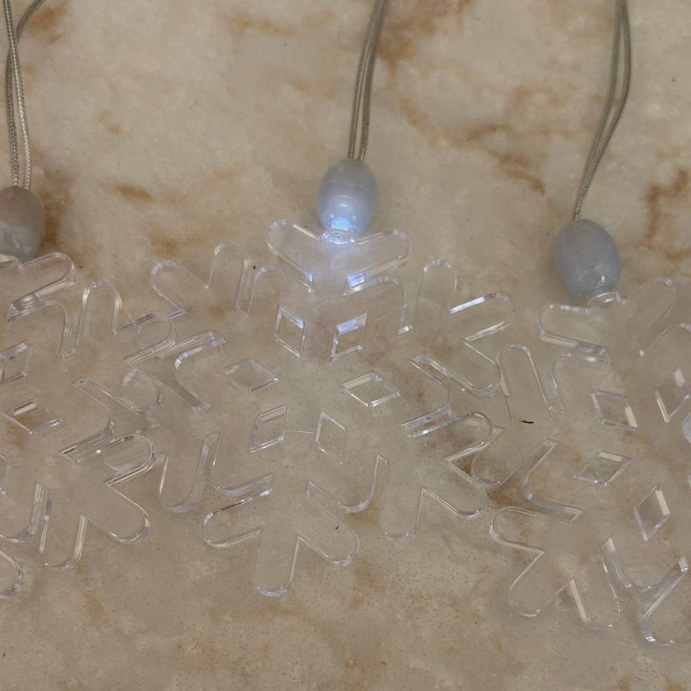 Set of 7 Individual Snowflake String Lights for hanging or wearing.